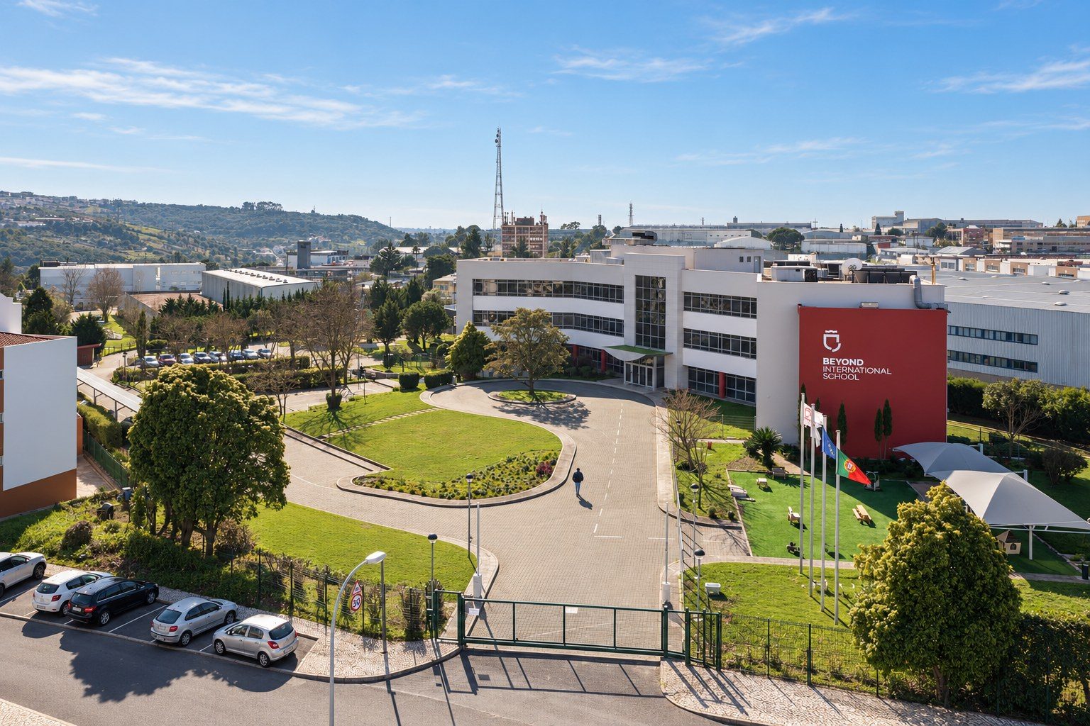 Beyond International School, a fachada vermelha da entrada com o logótipo da escola